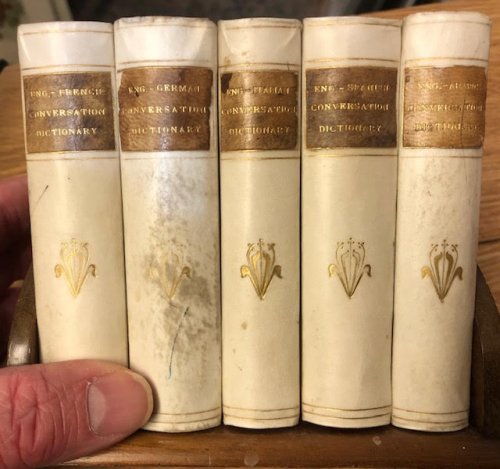 Dictionaries : English-French Conversation Dictionary. English-German Conversation Dictionary. English-Italian Conversation Dictionary. English-Spanish Conversation Dictionary. English-Arabic Conversation Dictionary. Five volumes in wooden bookcase