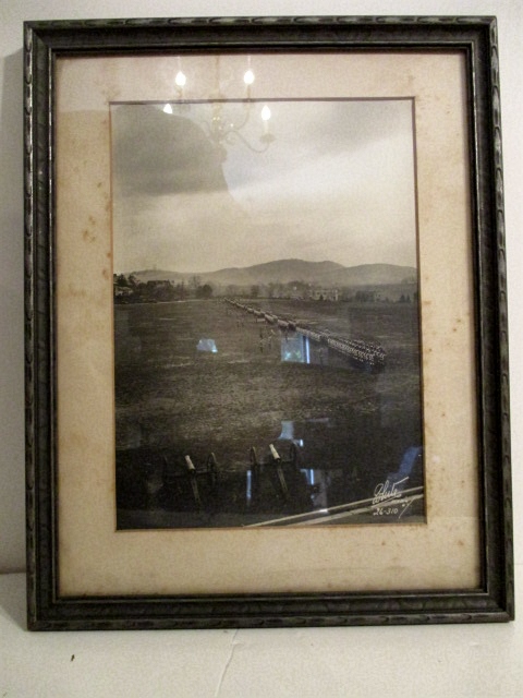 Framed Photograph of the Parade Ground with the Corps of Cadets drawn up for review. Two Civil War period field guns in foreground. Blue ridge mountains in distance.