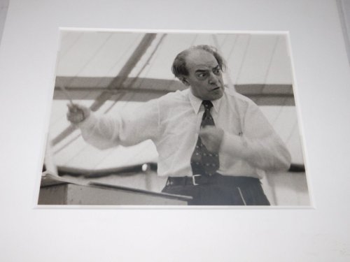 A WONDERFUL ORIGINAL PHOTOGRAPH OF THE GREAT BRAZILIAN CLASSICAL COMPOSER VILLA-LOBOS, HIS BATON A BLUR, AS HE CONDUCTS FROM A CRUDE PODIUM UNDER A TENT.
