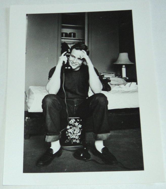 A BEAUTIFUL ORIGINAL PHOTOGRAPH OF A VERY YOUNG MARLON BRANDO, SEATED AT THE TELEPHONE IN FRONT OF HIS UNMADE BED.