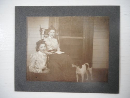 Photograph; Young Girl with Older Woman Readng on Porch with Dog