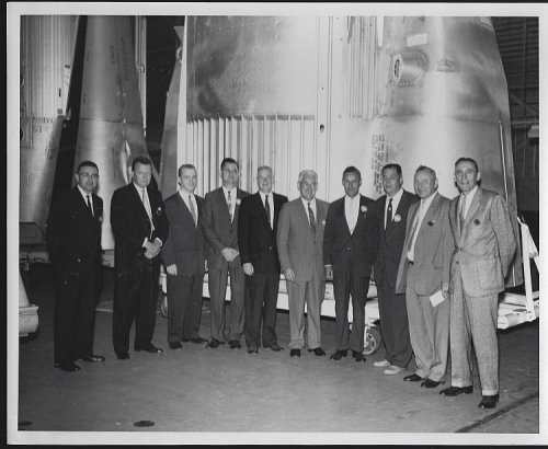 ORIGINAL PHOTOGRAPH OF LARGE GROUP OF MEN STANDING IN FRONT OF SATURN ENGINE, MARSHALL SPACE FLIGHT CENTER