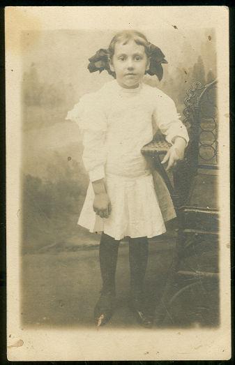 REAL PHOTO POSTCARD OF LITTLE GIRL IN WHITE WITH BIG BOW