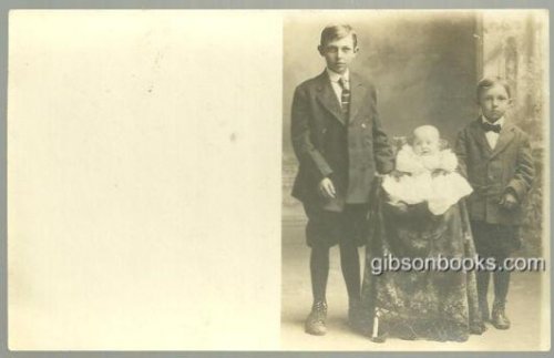 REAL PHOTO POSTCARD OF TWO BOYS STANDING WITH BABY