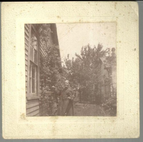 FRAMED MOUNTED PHOTOGRAPH OF OLDER WOMAN PICKING GRAPES