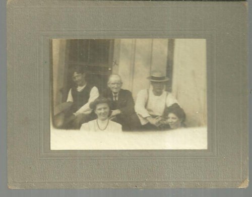 FRAMED MOUNTED PHOTOGRAPH OF FAMILY SITTING ON PORCH
